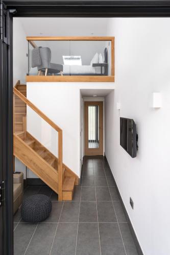 a room with a staircase and a tv on a wall at Romano Estate, The Courtyard in Penzance