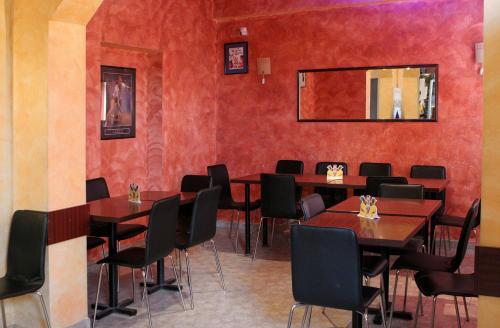 a dining room with tables and chairs and a mirror at Hotel Pamira in Sibiu