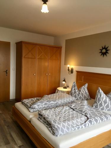 a bedroom with a large bed with pillows on it at Goldener Hahn Residence Ferienwohnungen mit Infrarot Sauna, Panorama Aussicht & Pool, Frühstücksservice im Aparthotel in Baiersbronn