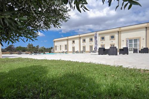 a building with a pool in front of it at Dimora Savarino Marzamemi Suites with pool in Marzamemi