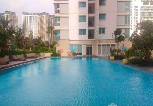 a large swimming pool in front of a building at 3BR apt Springhill Terrace, golf view in Jakarta