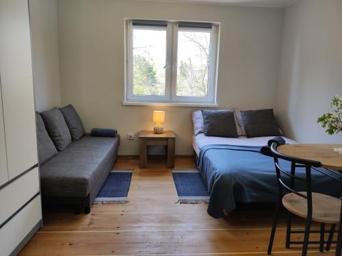 ein Wohnzimmer mit einem Sofa und einem Tisch in der Unterkunft Domek u Litwinów in Lipowiec