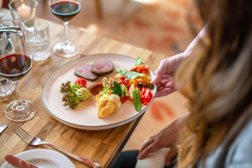 a woman sitting at a table with a plate of food at Diehls Hotel in Koblenz