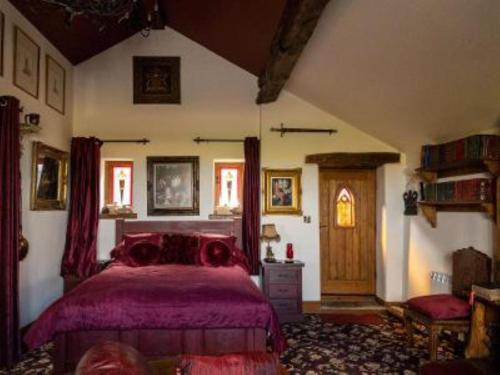 a bedroom with a purple bed in a room at Peak District Cottage set in 5 acres near Buxton in Buxton