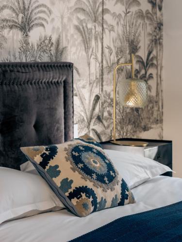 a bedroom with a bed with a pillow and a wallpaper at Le Nemours Rennes in Rennes