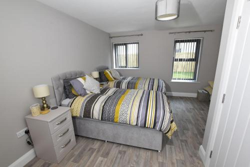 a bedroom with a bed and a nightstand and two windows at Homestead Hillsborough in Hillsborough