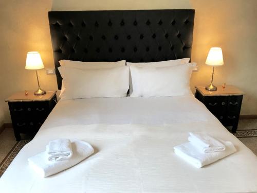 1 cama con toallas blancas y 2 lámparas en Guest House Le Contesse, en Florencia