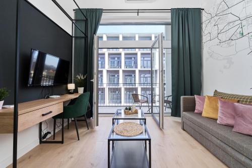a living room with a couch and a table at Airport Studio Zarembowicza by Noclegi Renters in Wrocław