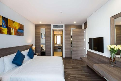 a bedroom with a large bed and a television at Best Western Plus Wanda Grand Hotel in Nonthaburi