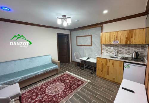 阿爾特溫省的住宿－Danzot Tatil Köyü，客房设有带沙发和桌子的厨房。