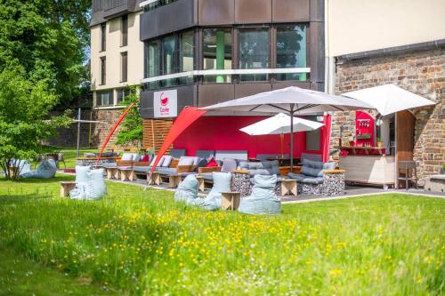 a group of chairs and umbrellas in front of a building at Diehls Hotel in Koblenz