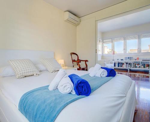a white bed with blue and white towels on it at VILLA BONANOVA STYLE in Palma de Mallorca