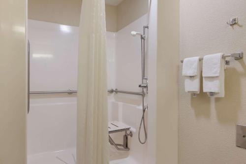a bathroom with a shower and a toilet and towels at Quality Inn Magnolia in Magnolia