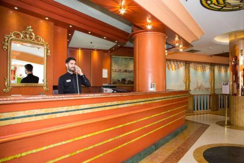 a man talking on a cell phone at a bar at Best Western Hotel Tritone in Mestre