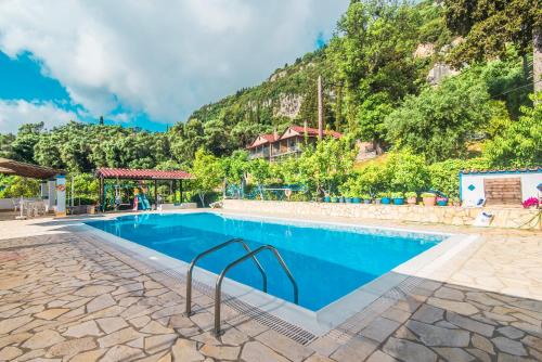a swimming pool with a mountain in the background at Andromaches apartment sea view in Achílleion