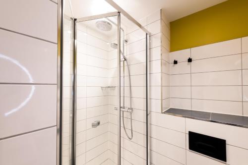 a shower with a glass door in a bathroom at Byron Hotel in London
