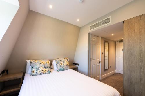 a bedroom with a white bed with two pillows at Byron Hotel in London