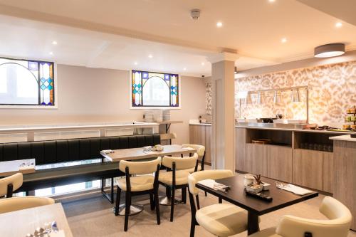 a restaurant with tables and chairs and a counter at Byron Hotel in London
