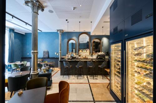 um restaurante com paredes azuis e um bar com bancos em Catalonia Plaza Catalunya em Barcelona