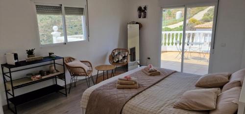 a bedroom with a large bed and a balcony at Villa Tranquila Arenas Malaga in Arenas