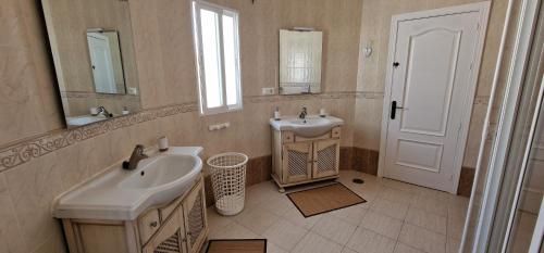 Baño blanco con lavabo y espejo en Villa Tranquila Arenas Malaga, en Arenas