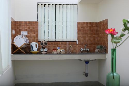 a bathroom counter with a sink and a window at Vrindhavan Mist City Resorts in Kanthalloor