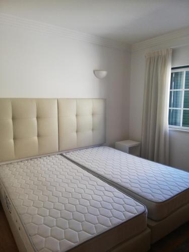 a large bed in a bedroom with a window at Villa V2 U in Olhos de Água
