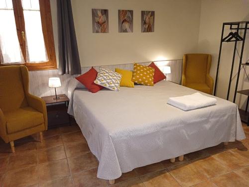 ベセイテにあるApartamento Burguésのベッドルーム1室(カラフルな枕付きのベッド1台付)