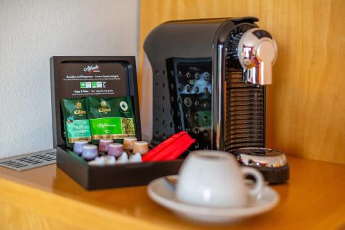 a coffee maker and a cup on a table at Diehls Hotel in Koblenz