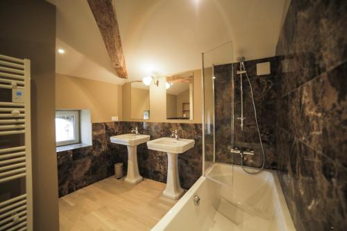 uma casa de banho com 2 lavatórios e um chuveiro em La Maison du Ballandreau em Monségur