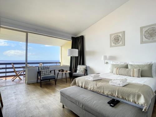 Schlafzimmer mit einem Bett und Meerblick in der Unterkunft Madeira Ocean View by Atlantic Holiday in Caniço