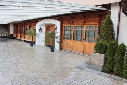 a building with wooden doors and a courtyard with plants at edelweiss lounge restaurant hotel pizza cafe billard gasthof in Mayrhofen