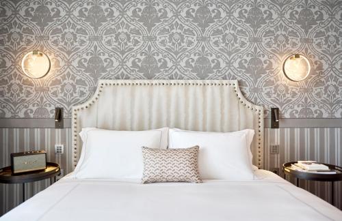 a bedroom with a white bed and a damask wallpaper at ON Residence - Small Luxury Hotels of the World in Thessaloniki