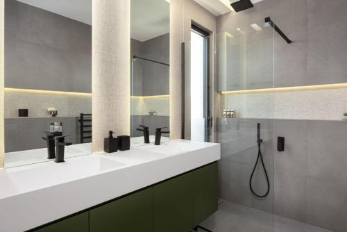 a bathroom with two sinks and a shower at Sounio Panoramic Loft in Sounio