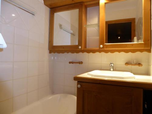 une salle de bain avec une baignoire, un lavabo et un miroir dans l'établissement Appartement 3 pièces avec terrasse, parking et accès pistes – Pralognan - FR-1-464-190, à Pralognan-la-Vanoise
