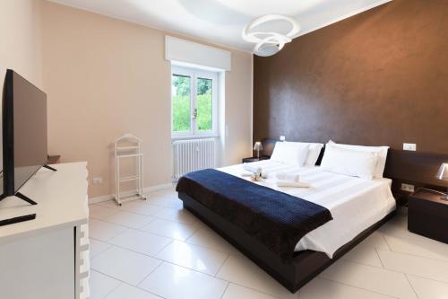 a bedroom with a large bed and a television at TERRAZZA SUL LAGO - Open Space e Netflix in Lecco