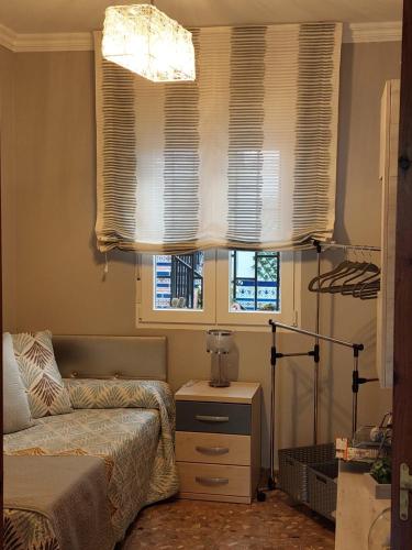 a bedroom with a bed and two windows with blinds at Elmiradordelasmurallas in Baeza