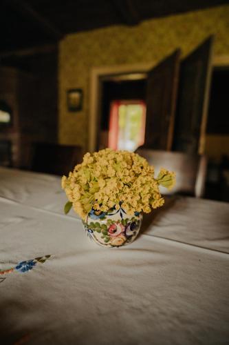 a vase filled with flowers sitting on a table at Muhu Tõnise Talu in Liiva