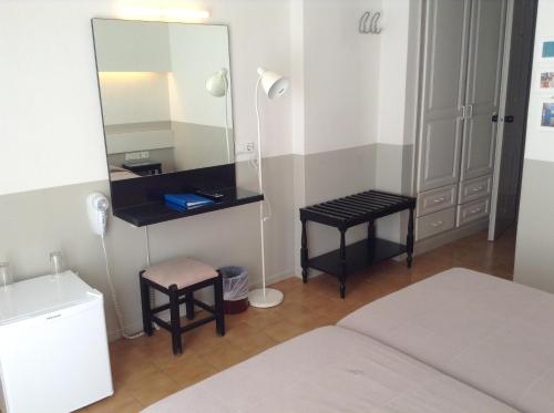- une chambre avec un miroir, un lit et un tabouret dans l'établissement Kamari Beach Hotel, à Kamari