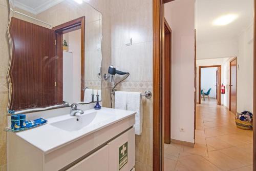 uma casa de banho com um lavatório e um espelho em Apartamento Sunlight by Sunnyway em Albufeira
