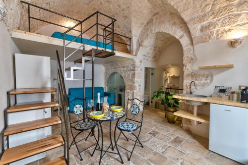 a room with a table and chairs and a loft bed at AROMA luxury in Ostuni