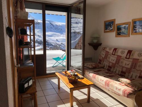 a living room with a couch and a table and a window at Appartement avec terrasse magnifique vue montagne in Saint-François-Longchamp