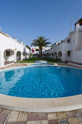 a large blue swimming pool in front of buildings at Casas Blancas Parque Montroig in Miami Platja