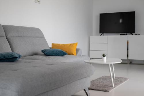 Sala de estar con sofá gris y mesa en Panoramic Sea View 3 rooms Apartment in Neptun. en Neptun
