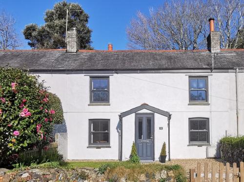 a white house with a blue door at Charlestown cottage, Woodburner, Gardens & Parking in Charlestown