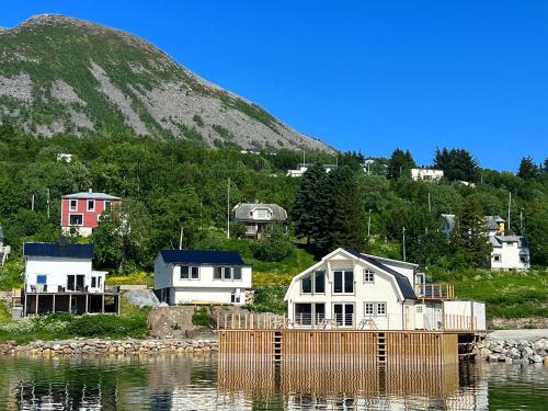 un grupo de casas en el agua junto a una montaña en Torsken Brygge en Torsken