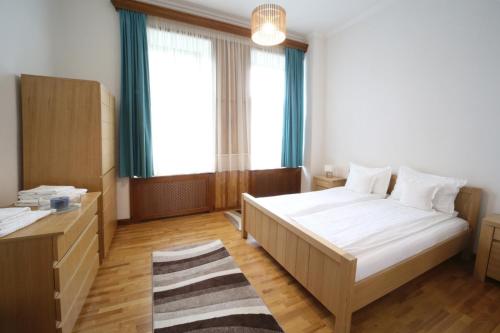 Schlafzimmer mit einem Bett, einem Schreibtisch und Fenstern in der Unterkunft Virág Apartman Luxury in Odorheiu Secuiesc