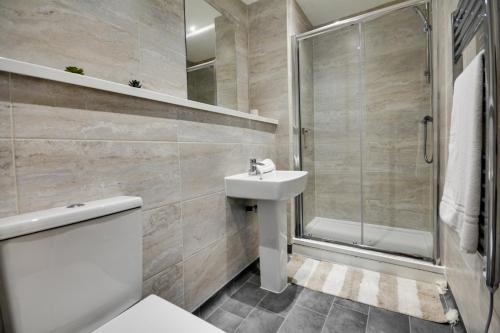 a bathroom with a toilet and a sink and a shower at City View Apartment in Liverpool