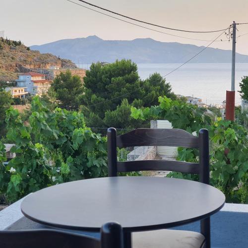 a white table and a chair on a balcony with a view at Villa Mehmeti in Sarandë