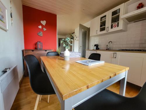 a kitchen with a wooden table and black chairs at Terrasses du Zimmerberg in Barr